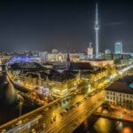 Foto en contrapicado de la ciudad de Berlín durante la noche, con las luces encendidas.